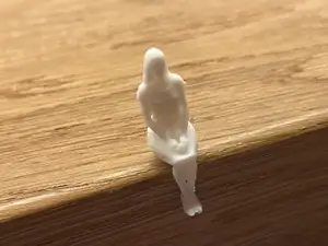Kleine sitzende Frau mit Kleid