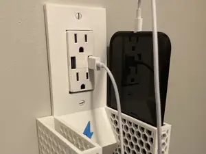 Outlet mounted phone holder