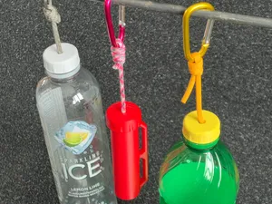 Cap to hang or carry 2L soda bottles with a rope