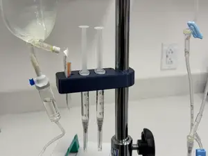Syringe holder with IV pole clamp and needle holder