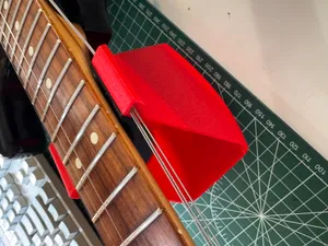 Guitar neck rest with string retainers