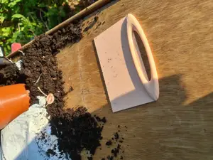 Broad scraper for potting table or other flat surfaces that need clearing