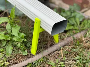 Ground support for downspout rain gutter