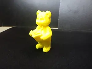 A cute teddy bear(Fitzgerald) standing, reading a book.