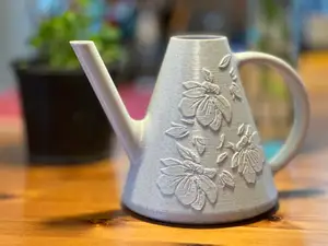 Decorative watering can with embossed floral designs
