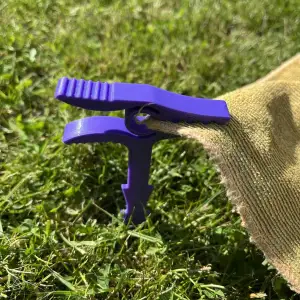 Peg to hold beach blanket against wind