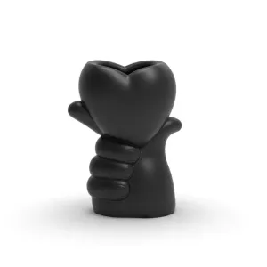 A vase in the shape of a hand holding a heart
