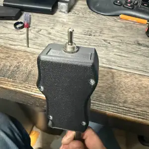 Handheld toggle switch grip